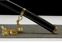 Black sword with gold accents on a textured surface
