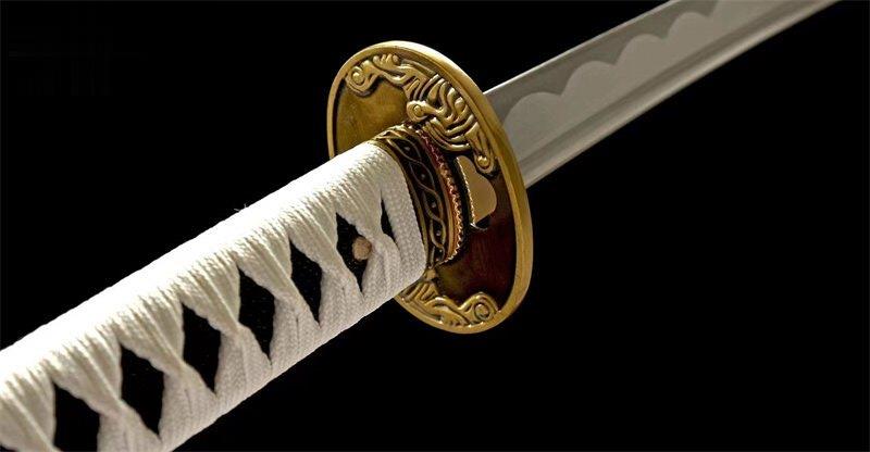 Sword with a gold guard and white handle against a black background